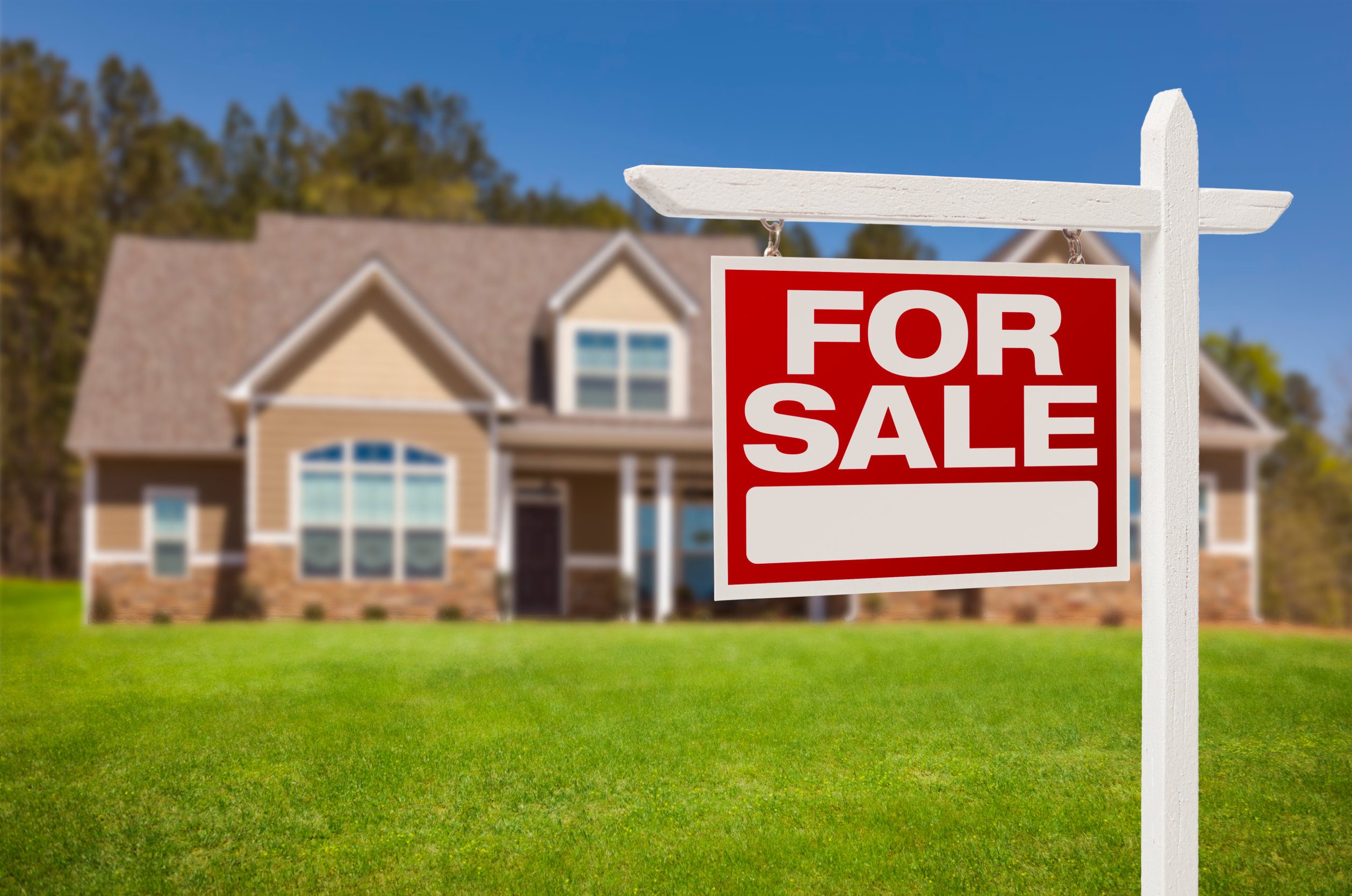 Home For Sale Real Estate Sign in Front of Beautiful New House.